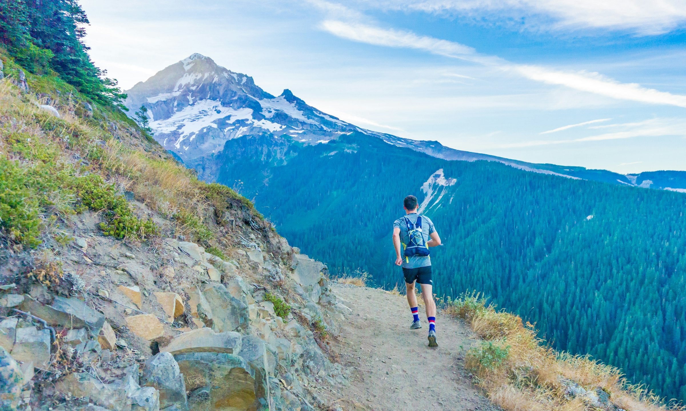 Trail runner moving along a mountain ridge at dusk
